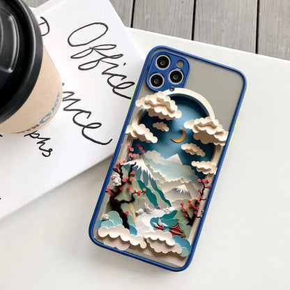 Phone case with a mountain and cloud design on a white surface with a coffee cup and book.