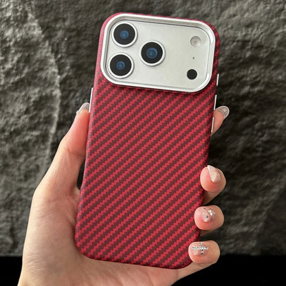 Hand holding a phone with a red carbon fiber case against a dark textured background