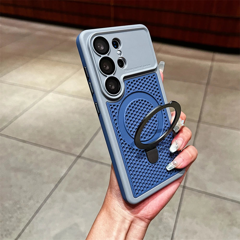 A hand holding a blue and gray protective phone case with a textured magnetic ring holder, shown against a tiled floor background.