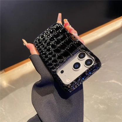 Hand holding a black crocodile-patterned phone case with a reflective surface.
