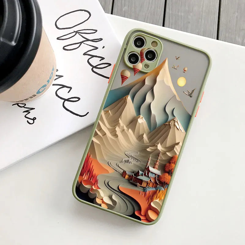 Phone case with mountain design on a white surface next to a coffee cup