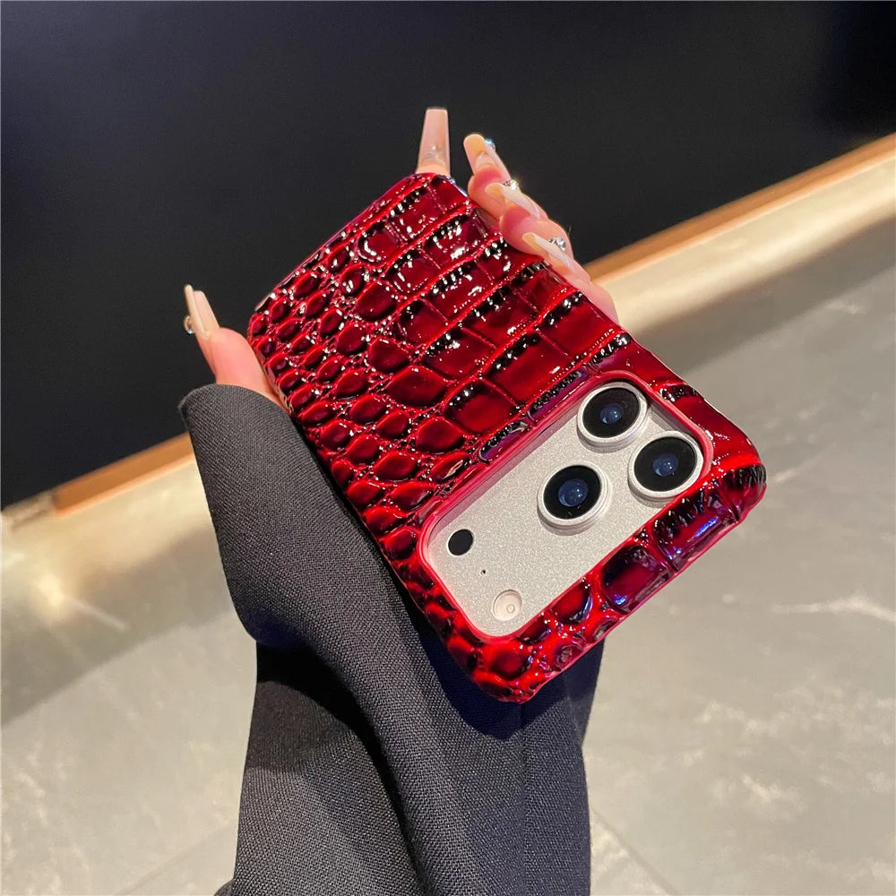 Red crocodile-patterned phone case held by a hand against a dark background