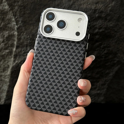 Hand holding a phone case with a geometric pattern against a dark background
