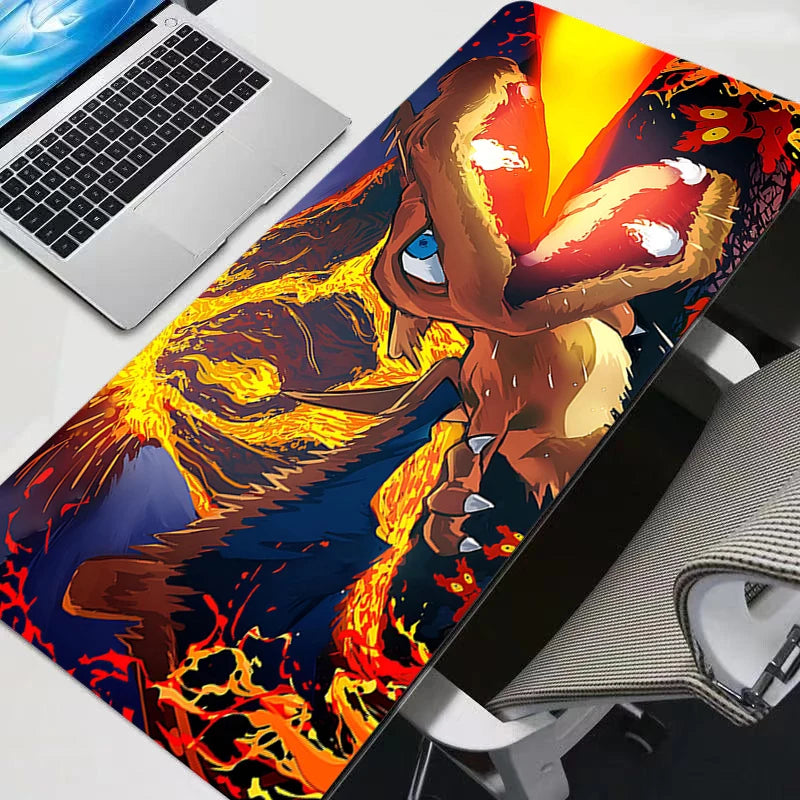 Laptop on a large dragon-themed mouse pad with a computer mouse and headset.
