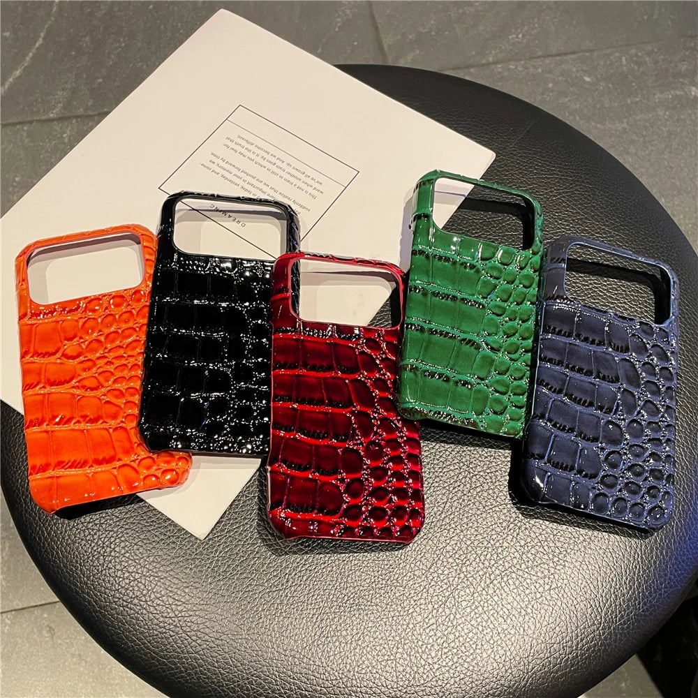 Five phone cases with different colors and patterns on a round surface.