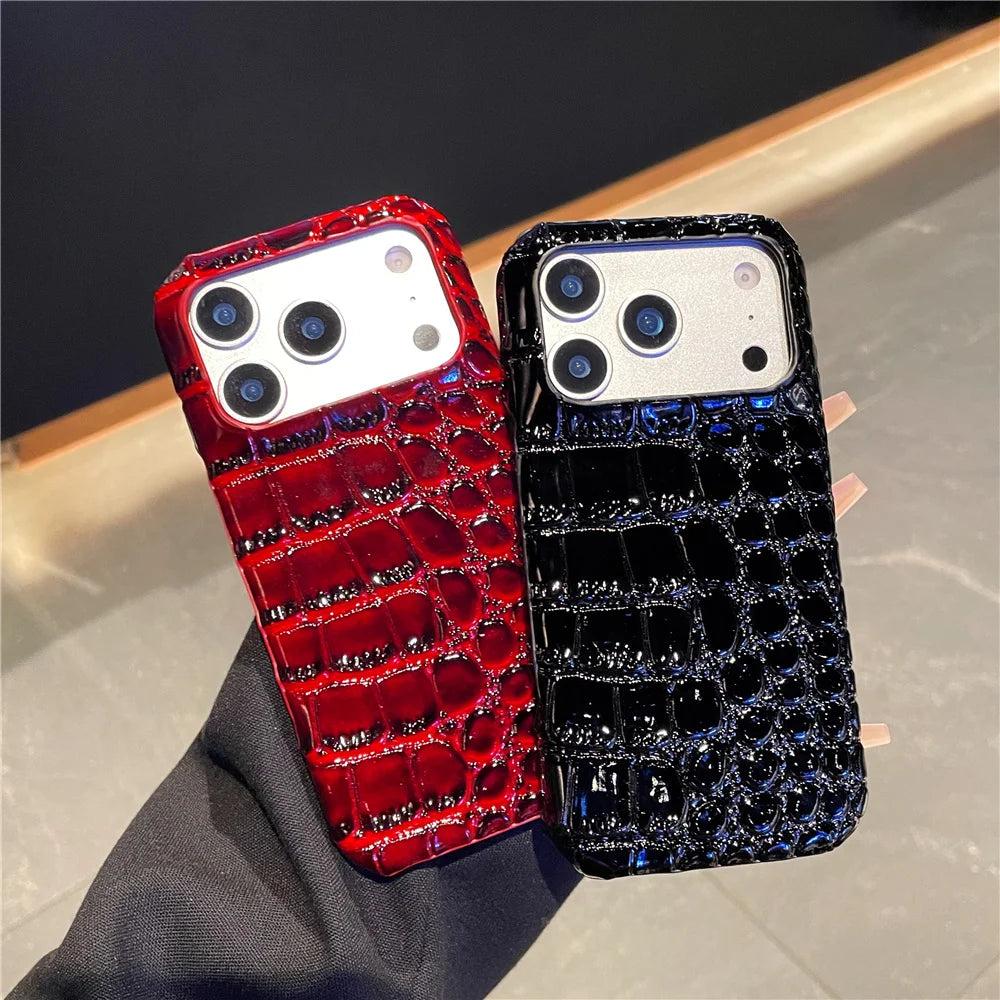 Two phone cases, one red and one black, with crocodile texture on a neutral background.