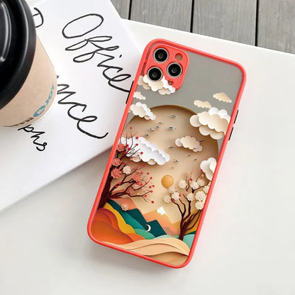 Phone case with a mountain and cloud design on a white surface with a coffee cup and book.