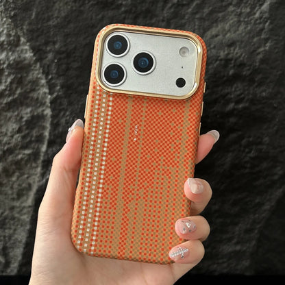 Hand holding an orange textured phone case against a dark background
