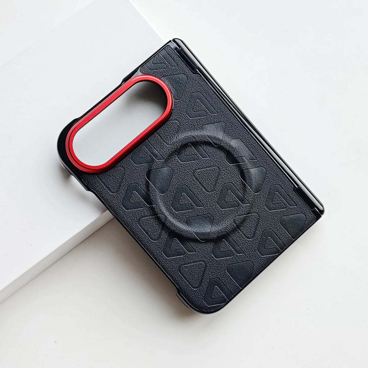 Black textured phone case with a red metallic camera ring, featuring a circular magnetic grip design on the back, shown on a clean white background.