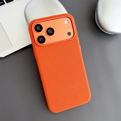 Orange phone case on a gray surface with a blurred background