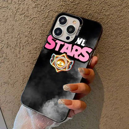 A hand holding a black phone case with a pink 'STARS' graphic, a small yellow and orange emblem, and 'NL' text, shown against a textured beige wall.