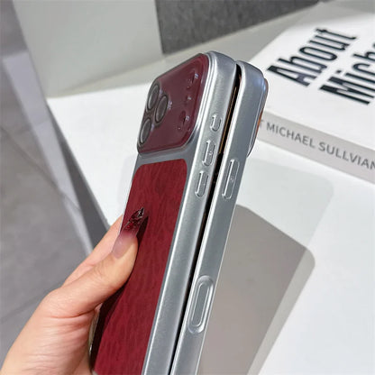 A hand holds a slim smartphone case shown from the side, featuring a deep burgundy wood-grain back panel and a metallic silver frame. The phone inside is partially visible.