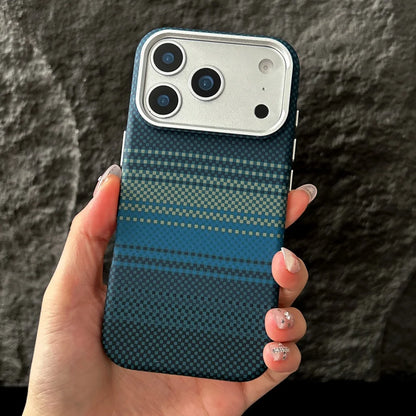 Hand holding a phone case with a blue and black pattern against a dark background