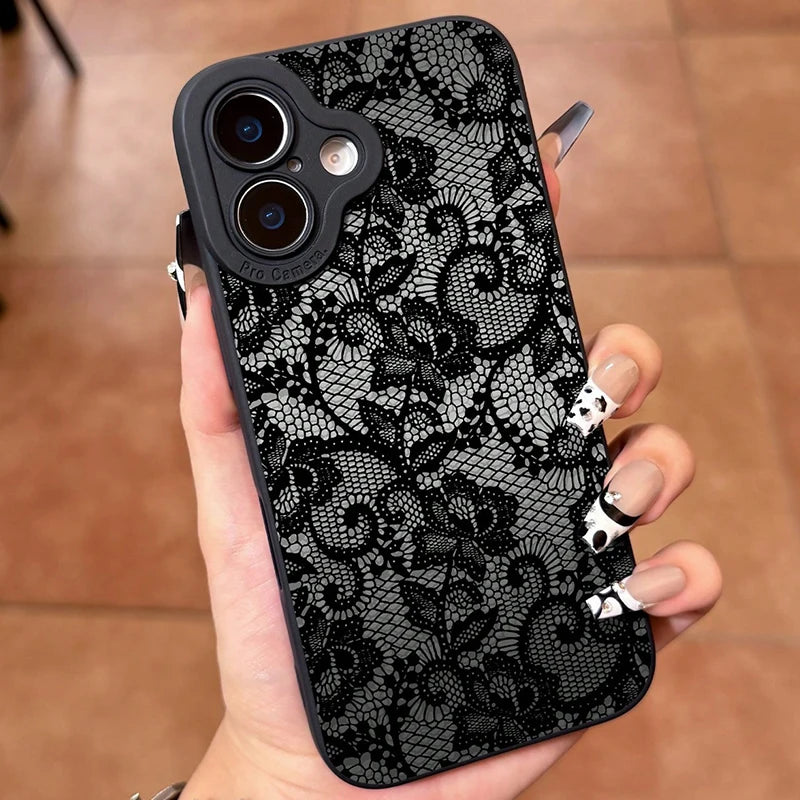 Phone case with black lace pattern held in a hand on a wooden floor.