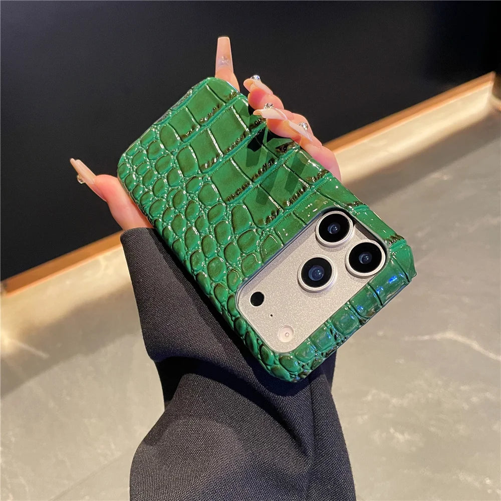 Green crocodile texture phone case held by a hand against a neutral background
