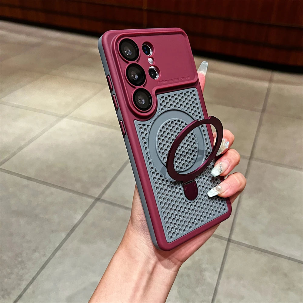 A hand holding a dark red and gray protective phone case with a built-in ring stand, shown against a tiled indoor background.