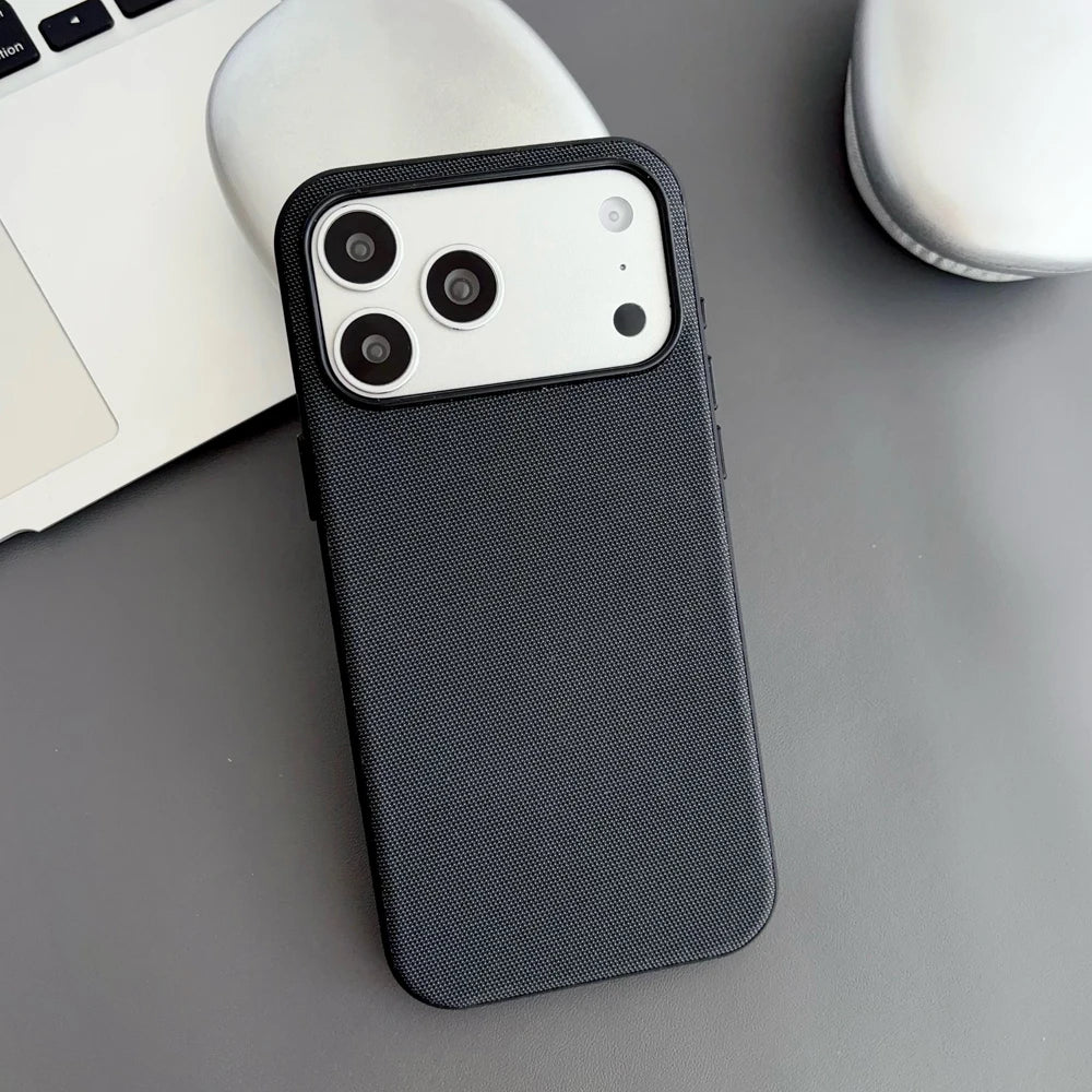 Black phone case on a desk with a laptop and mug in the background