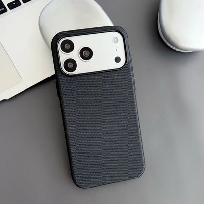 Black phone case on a desk with a laptop and mug in the background