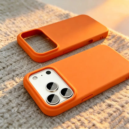 Two bright orange phone cases shown on a textured beige woven surface, with one case fitted on a smartphone and the other left empty.